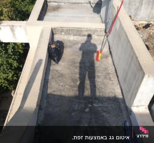 גג עם אנטנה, מטאטא ושקית זבל שחורה